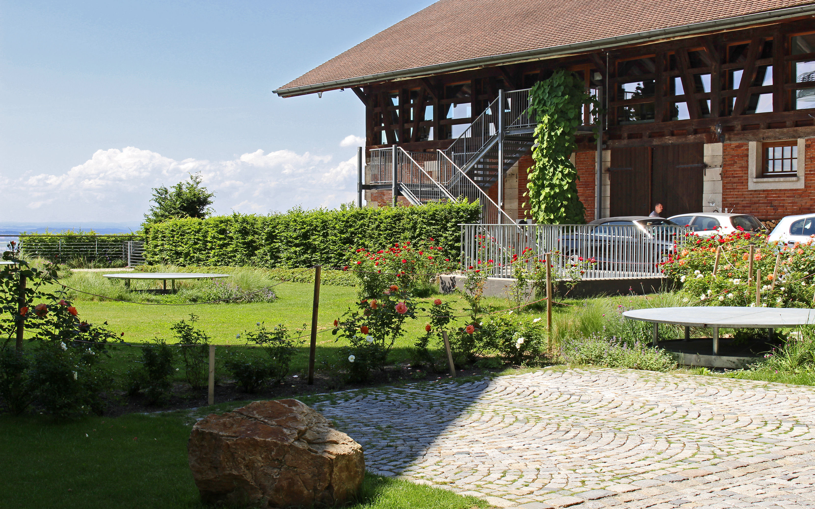 Roof garden with lawn, rose bushes and natural stone paving